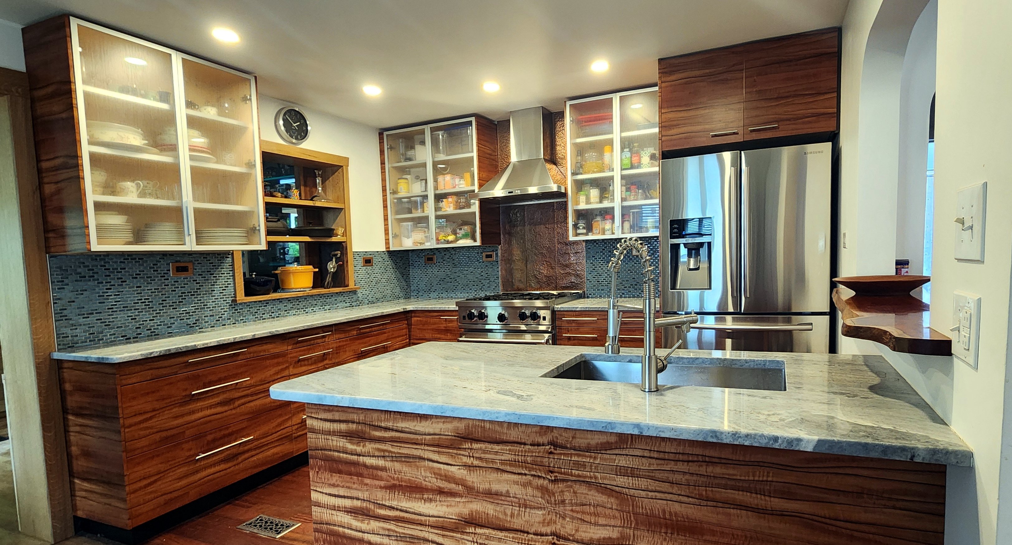 Custom figured koa kitchen cabinetry with marble island by Eclipse Craftworks
